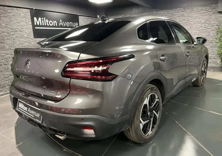 Vue 3/4 arrière droite d'une Citroën C4 X gris métallisé avec jantes alliage 18'' et feux LED en V.