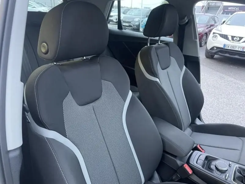 Vue intérieure rapprochée des sièges avant noirs avec surpiqûres grises de l'Audi Q2 blanc 30 TFSI 116 SPORT LIMITED 2020.
