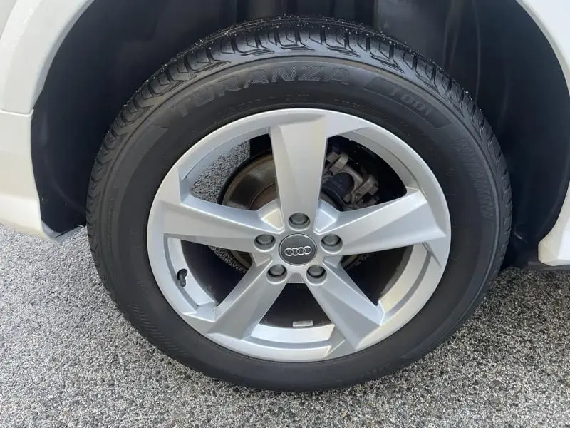 Gros plan sur la roue avant droite blanche d’un Audi Q2 30 TFSI 116 SPORT LIMITED avec jante alliage cinq branches.