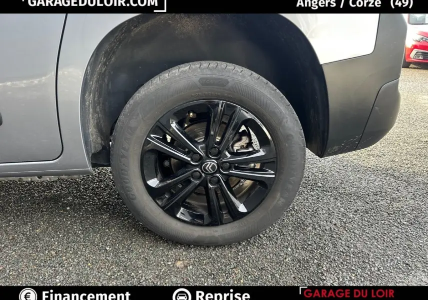 Gros plan sur la roue avant gauche noire brillante d’un Citroën Berlingo gris clair 2024, avec jante en alliage.