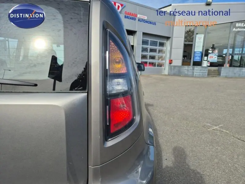 Gros plan sur le feu arrière droit d'une KIA SOUL 2010 gris métallisé, avec reflet du soleil sur la vitre arrière.