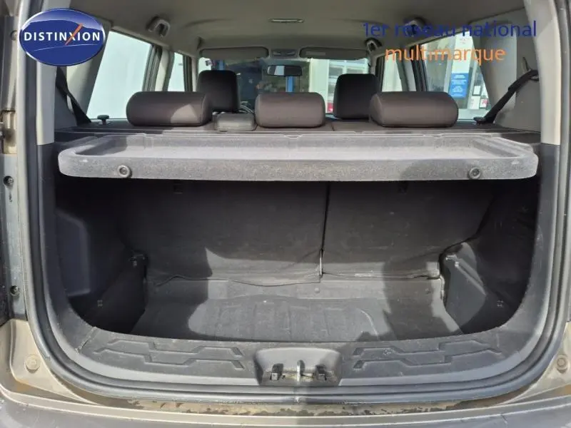 Vue arrière du coffre ouvert d'une KIA SOUL 1.6 16v Plug 2010, intérieur noir avec cache-bagages en place.