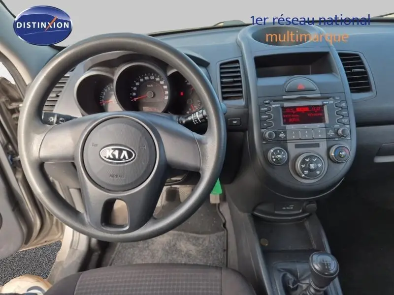 Vue intérieure du tableau de bord et volant noir d'une KIA SOUL 1.6 16v Plug essence 2010 avec console centrale et commandes visibles.