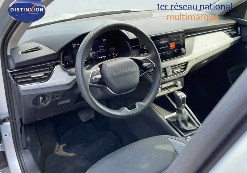 Vue intérieure côté conducteur du Skoda Kamiq gris argent, avec volant multifonction et tableau de bord digital.