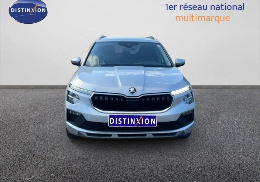 Vue frontale d'un Skoda Kamiq gris argent métal 2025 avec calandre noire et feux LED allumés.