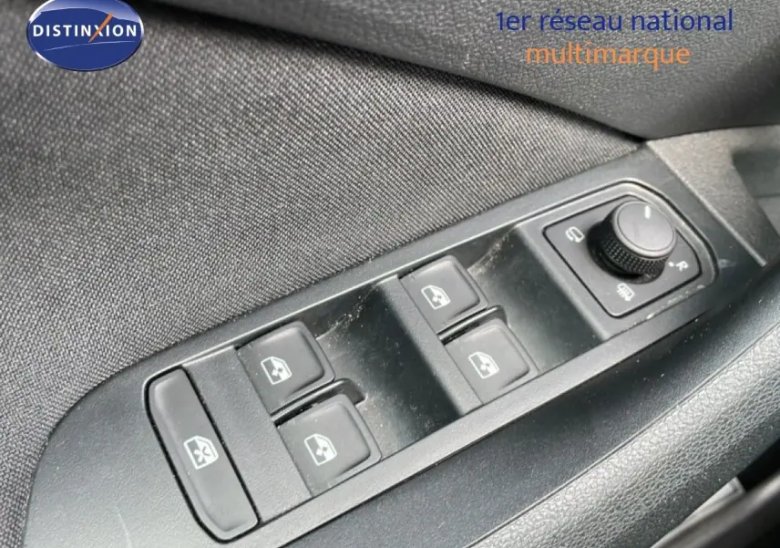 Gros plan sur les commandes de lève-vitres et réglage des rétroviseurs côté conducteur d’un Skoda Kamiq gris argent 2025.