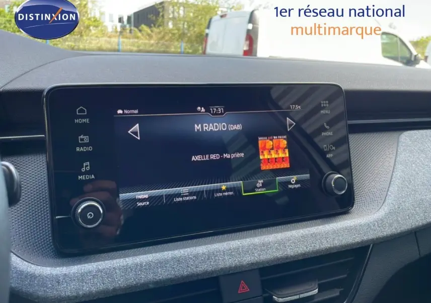 Gros plan sur l'écran tactile central du Skoda Kamiq gris argent, affichant la radio numérique avec menu clair.