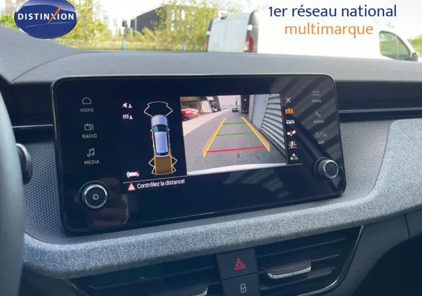 Écran central du Skoda Kamiq gris argent 2025 montrant la caméra de recul avec guidage de trajectoire coloré.