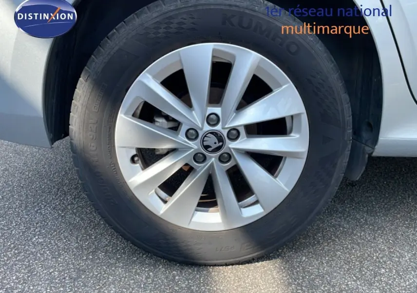 Gros plan sur la roue avant droite gris argent métallisé d’un Skoda Kamiq 2025 avec jante alliage et logo central visible.