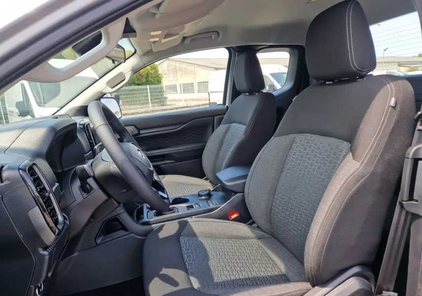 Vue intérieure côté conducteur du Ford Ranger Super Cabine gris Iconic, montrant les sièges avant et le tableau de bord.