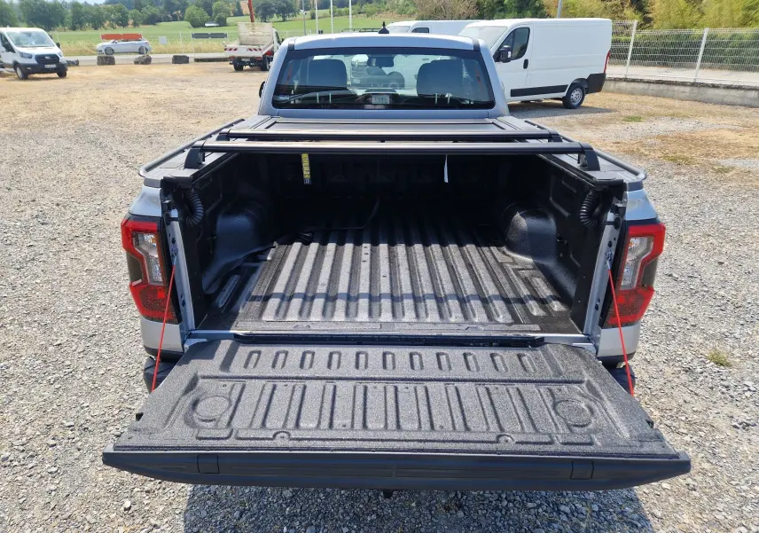 Vue arrière du Ford Ranger Super Cabine gris Iconic avec plateau ouvert et rideau rigide coulissant visible.