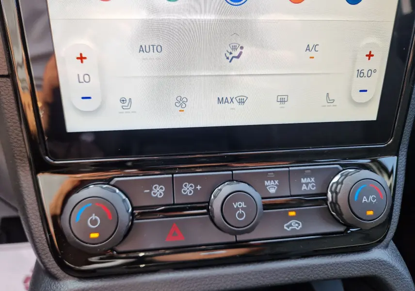 Gros plan sur la console centrale du Ford Ranger Super Cabine 2026, montrant les commandes de climatisation et volume.