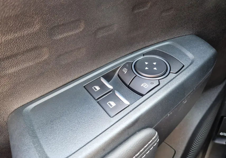 Gros plan sur les commandes de réglage des rétroviseurs et des vitres côté conducteur du Ford Ranger Super Cabine gris Iconic.
