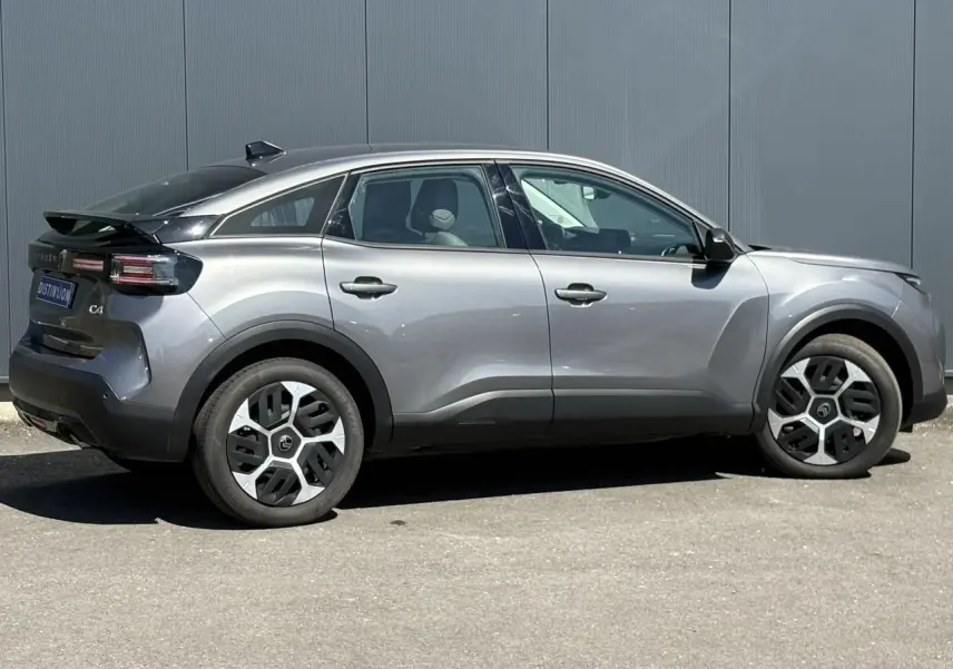 Vue latérale droite d'une Citroën C4 Hybrid 145 gris Mercury avec jantes distinctives et toit noir.