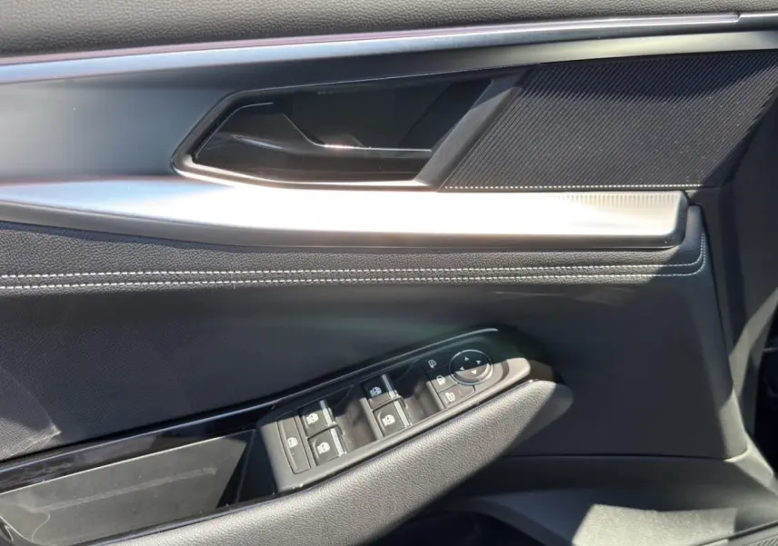 Détail de la porte côté conducteur noire du Renault Rafale 2025 avec commandes des vitres et rétroviseurs.