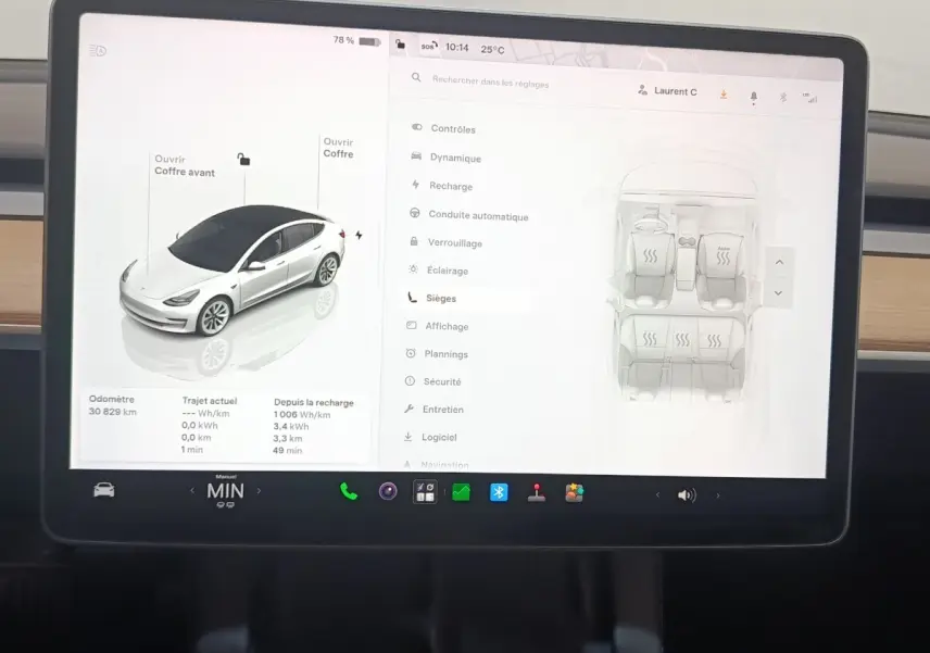 Écran tactile central de Tesla Model 3 blanc 2022 affichant les réglages des sièges et état du véhicule en vue intérieure.