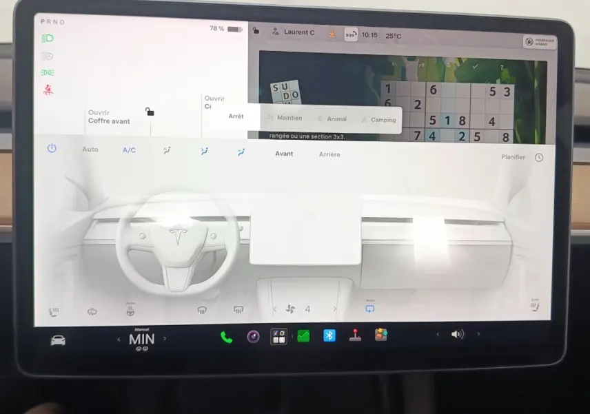 Écran tactile central de la Tesla Model 3 blanche 2022, affichant tableau de bord et commandes climatisation.