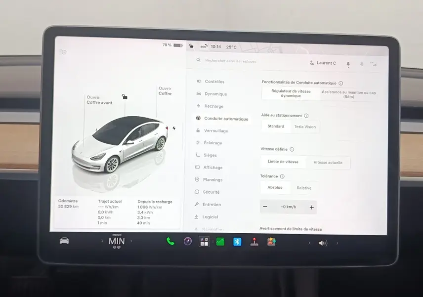 Écran tactile central affichant les réglages de conduite autonome d'une Tesla Model 3 blanche, vue intérieure.