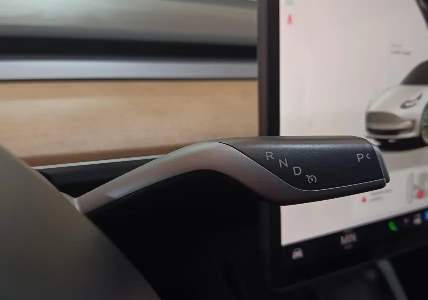 Le levier de vitesses gris et noir de la Tesla Model 3 Grande Autonomie 2022, vue intérieure rapprochée.