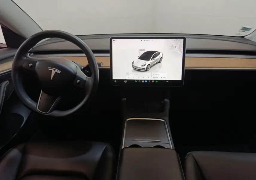 Vue intérieure frontale du tableau de bord noir avec écran tactile central et volant Tesla Model 3 Grande Autonomie 2022.