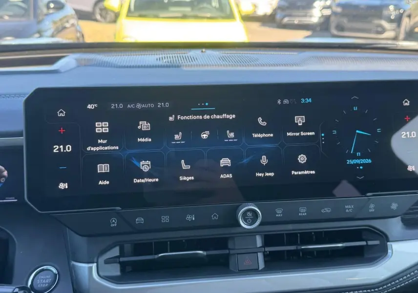 Vue rapprochée de l’écran tactile central du Jeep Compass 2026 avec interface multifonction et commandes climatisation.