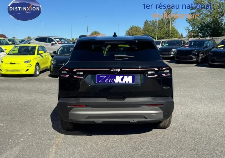 Vue arrière d'un Jeep Compass 2026 noir avec toit noir, stationné sur un parking en plein jour.