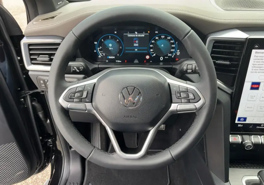 Vue rapprochée du volant et du tableau de bord numérique d'un Volkswagen Amarok simple cabine noir 2025.