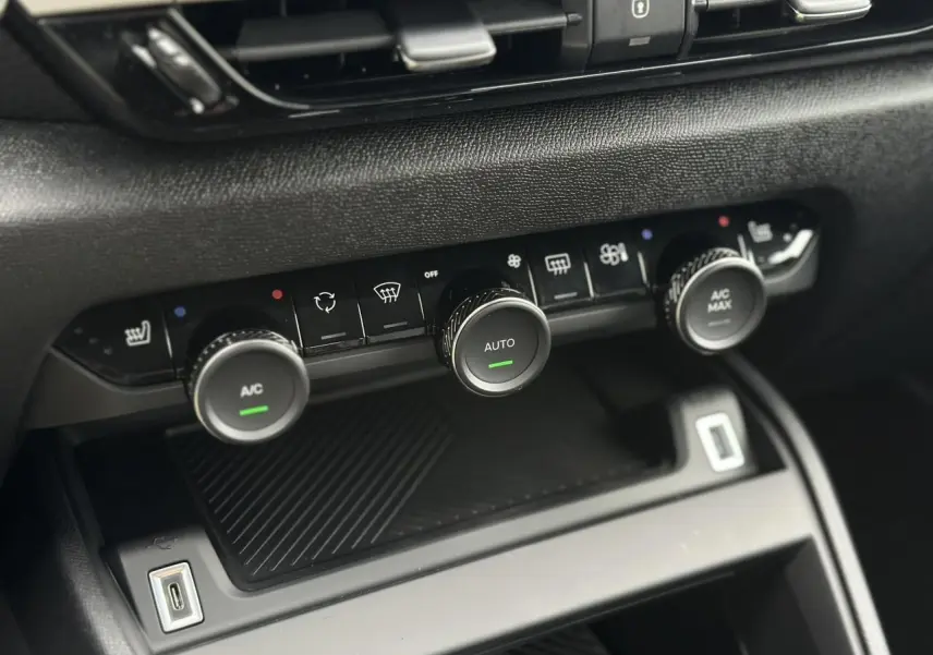 Gros plan sur la console centrale noire du Citroën C4 Manhattan Green 2025, avec commandes climatisation et USB visible.