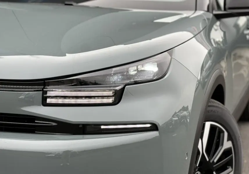 Gros plan sur l'avant droit de la Citroën C4 Manhattan Green avec ses phares LED et jante alliage noire et argent.