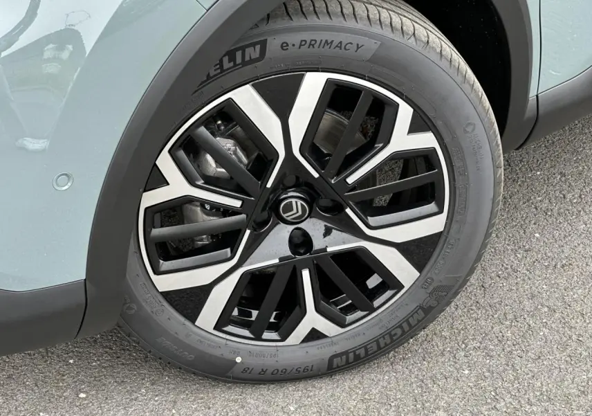 Gros plan sur la jante alliage 18'' AMBER diamantée noire et argentée du côté avant gauche d'une Citroën C4 Manhattan Green.