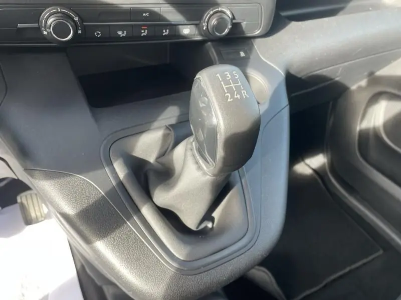 Gros plan sur le levier de vitesses manuel du Peugeot Rifter blanc 2020, avec console centrale et commandes de climatisation visibles.