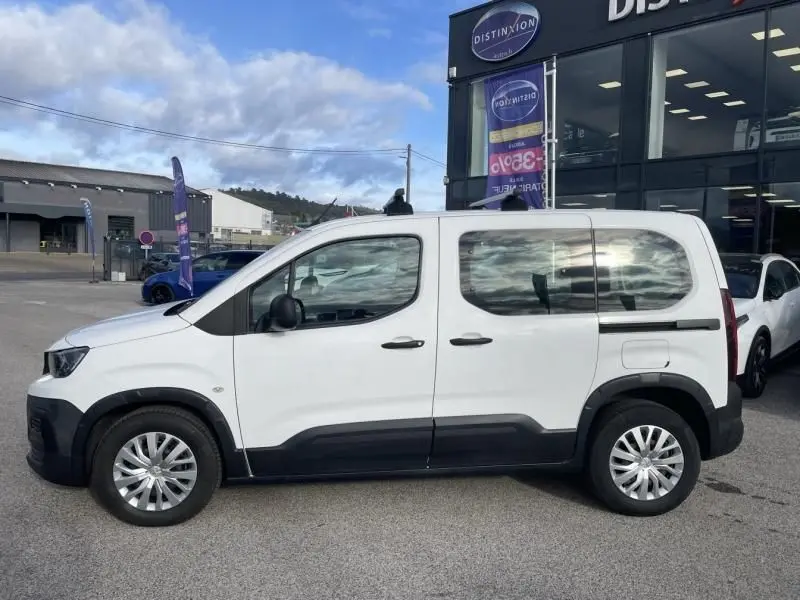 Vue de profil côté gauche d’un Peugeot Rifter blanc 1.5 HDI 100 Active diesel 2020 avec protections noires sur les bas de caisse.