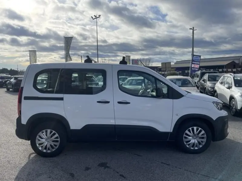 Vue de profil côté gauche d'un Peugeot Rifter blanc 1.5 HDI 100 Active 2020 avec protections noires sur les bas de caisse.