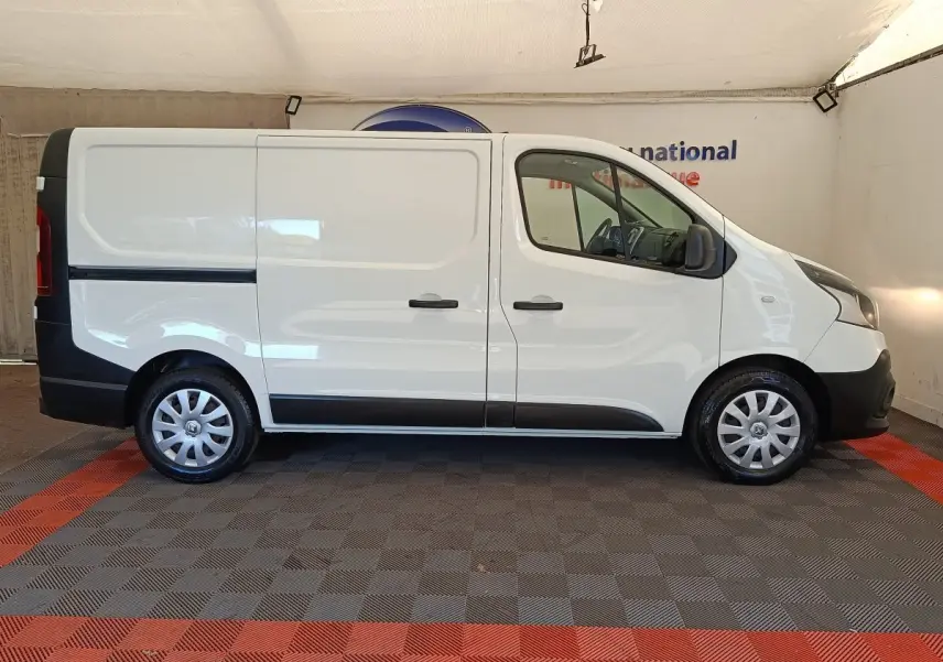 Profil droit du Renault Trafic Fourgon blanc de 2017 avec portes latérales pleines et jantes acier.