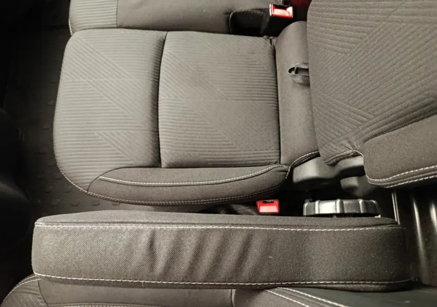 Gros plan sur les sièges avant gris foncé du Renault Trafic Fourgon, avec coutures blanches visibles.