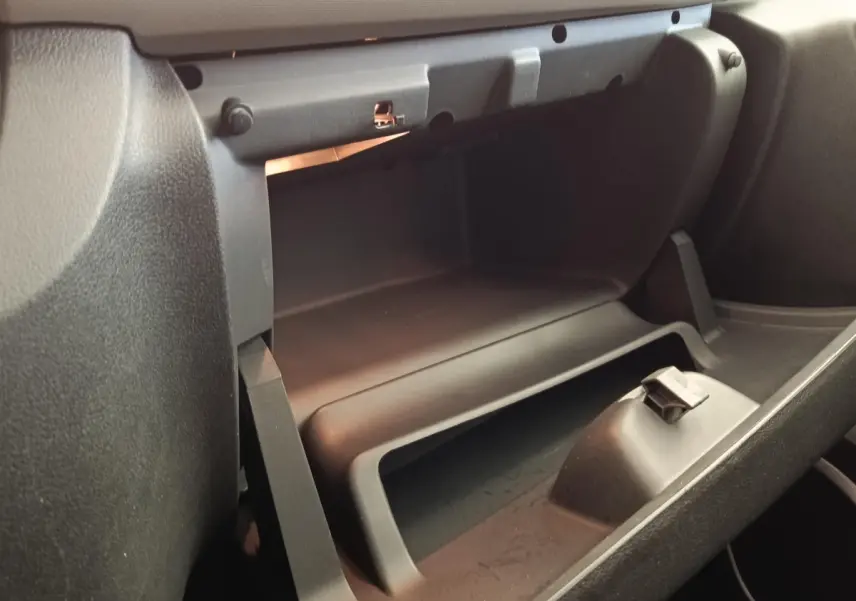 Intérieur du Renault Trafic Fourgon 2017, vue rapprochée de la boîte à gants ouverte côté passager, plastique noir mat.
