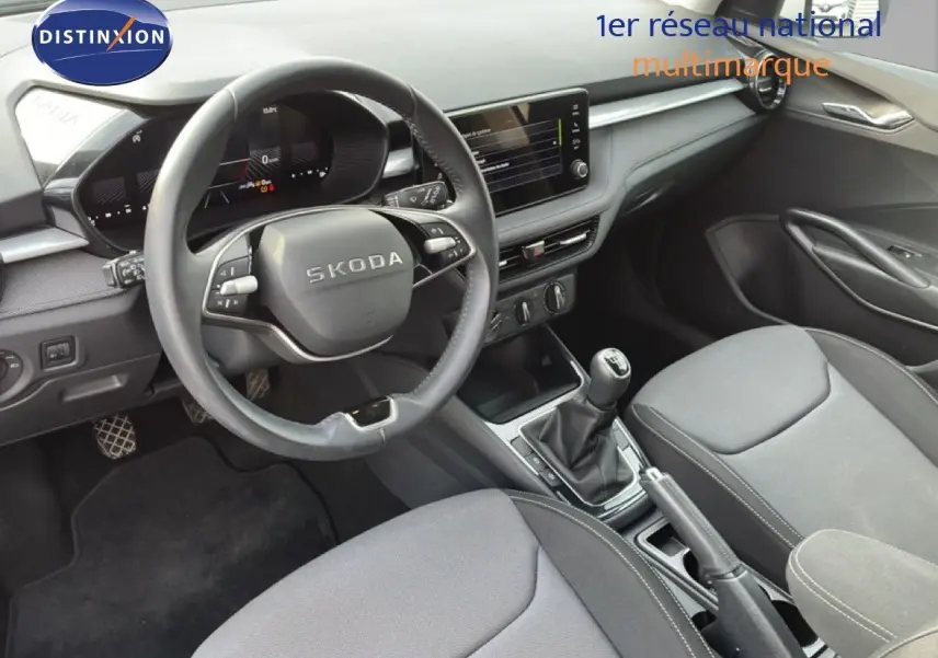 Vue intérieure de la Skoda Fabia 2025 montrant le tableau de bord, volant cuir multifonction et console centrale avec boîte manuelle.