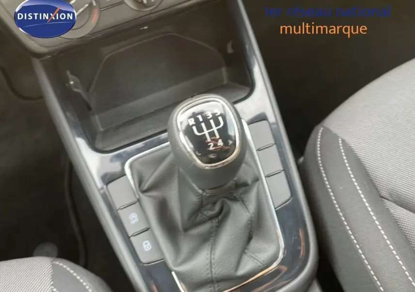 Gros plan sur le levier de vitesses manuel noir et la console centrale d’une Skoda Fabia blanc glacier, intérieur tissu gris.