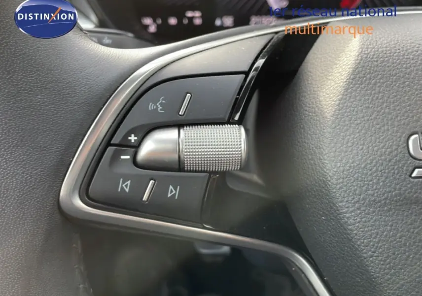 Gros plan sur les commandes multifonctions à gauche du volant cuir d'une Skoda Fabia blanc glacier 2025.