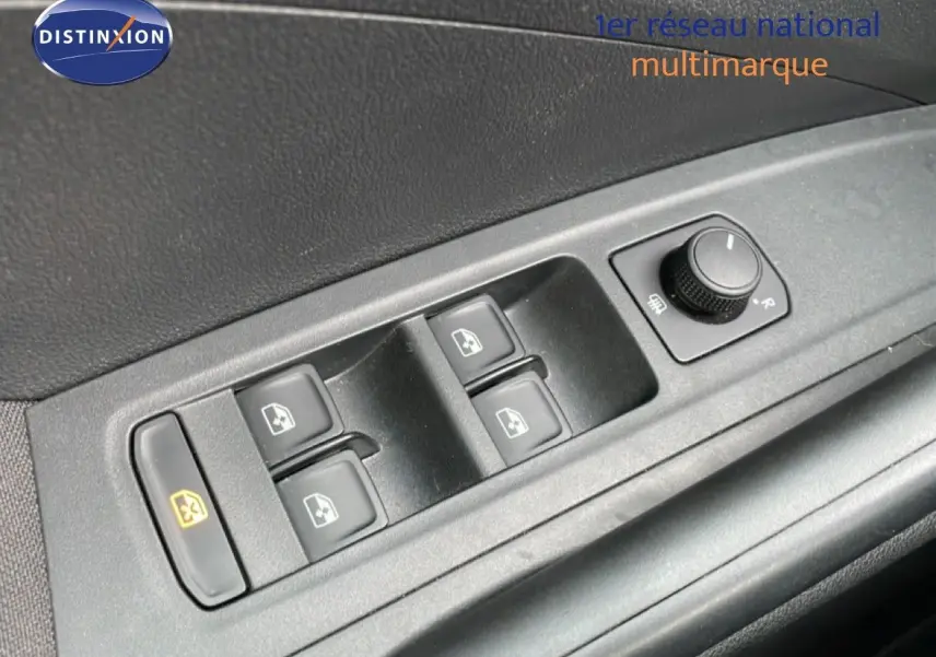 Gros plan sur les commandes de lève-vitres et réglage des rétroviseurs côté conducteur d'une Skoda Fabia blanche Glacier 2025.