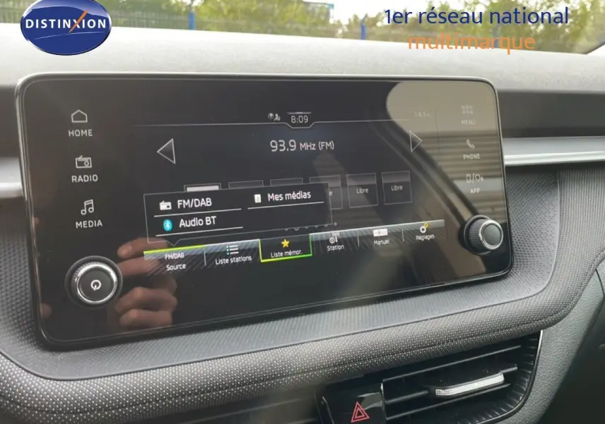 Écran tactile central de la Skoda Fabia 2025 montrant l'interface radio FM/DAB avec commandes autour et finition intérieure grise.