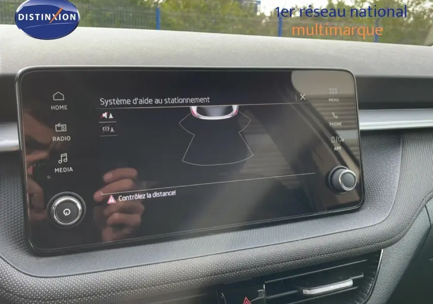 Écran tactile du système d'aide au stationnement dans l'habitacle d'une Skoda Fabia blanc glacier, vue de face.