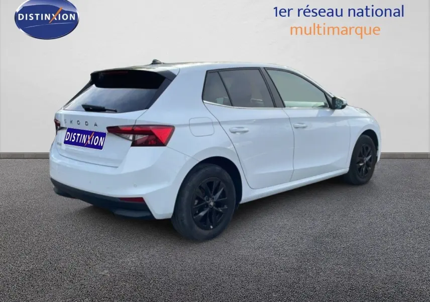 Vue 3/4 arrière droite d'une Skoda Fabia blanc glacier avec jantes noires et vitres teintées.