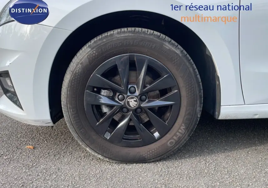 Gros plan sur la roue avant gauche noire avec jante en alliage du Skoda Fabia blanc glacier 2025.