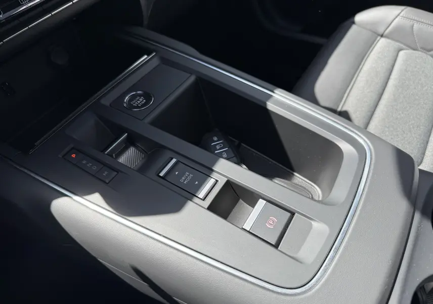 Vue rapprochée de la console centrale grise du Citroën C5 Aircross Hybrid 2025 avec bouton start/stop et commandes de boîte auto.