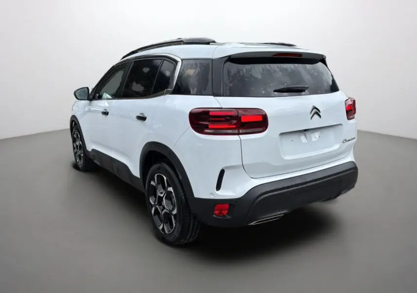 Vue 3/4 arrière droite d'un Citroën C5 Aircross Hybrid blanc Okenite avec jantes biton et feux LED distinctifs.