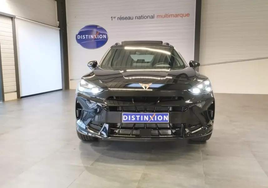 Vue frontale d'un CUPRA Formentor noir métal 2026 avec logo CUPRA doré et phares Full LED allumés en intérieur showroom.