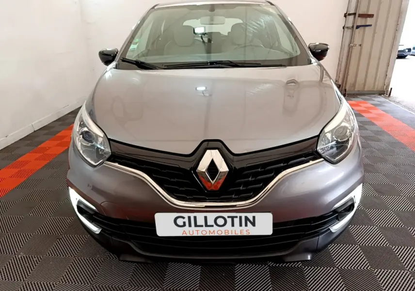 Vue frontale d'une Renault Captur gris foncé avec feux diurnes LED allumés et logo marqué au centre de la calandre.
