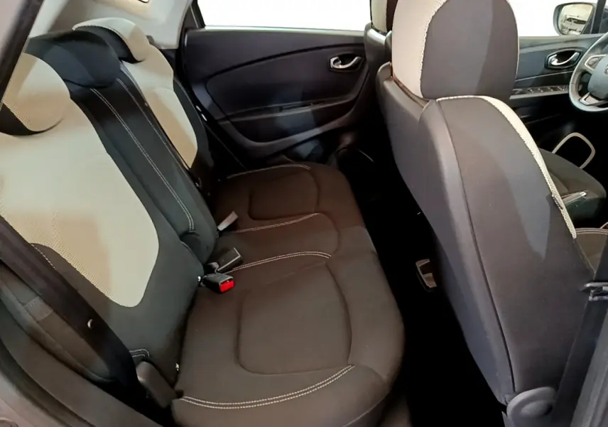 Vue intérieure côté arrière droit du Renault Captur 2018, sièges tissu bicolore gris clair et foncé.