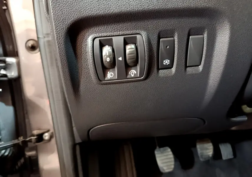 Vue rapprochée des commandes d’éclairage et d’assistance au freinage côté gauche du tableau de bord d’un Renault Captur gris foncé 2018.